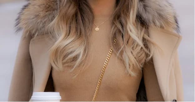 Close-up of a person in a coat with a coffee cup